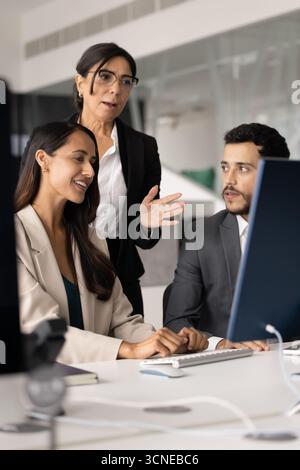 Senior and younger diverse professionals discussing online project Stock Photo