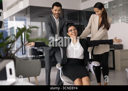 Relaxed carefree senior business leader woman riding comfortable office chair Stock Photo