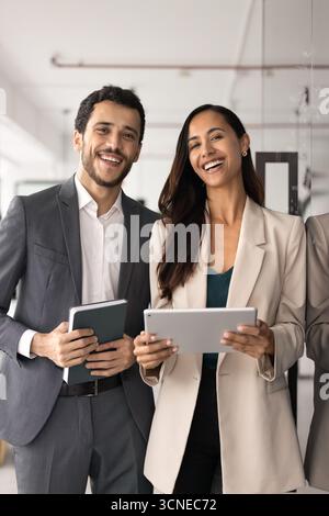 Positive young diverse professional man and woman standing together Stock Photo
