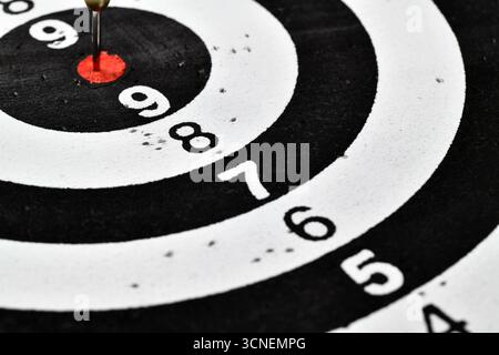 A black and white target with a red bullseye and the numbers 1 through 9 on it. Stock Photo
