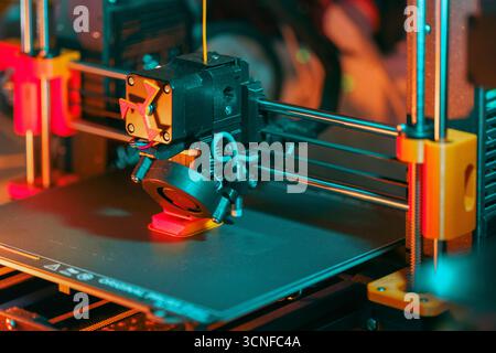3D printer printing object modern prototyping process with visible extruder, moving axis and plastic filament deposition in high-tech engineering work Stock Photo