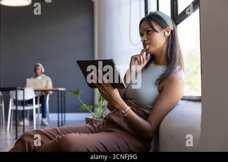 Diverse coworkers using tablet and laptop, working at modern space, copy space Stock Photo
