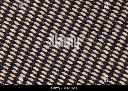 Detailed close up of black and beige woven textile pattern showing diagonal thread structure Stock Photo