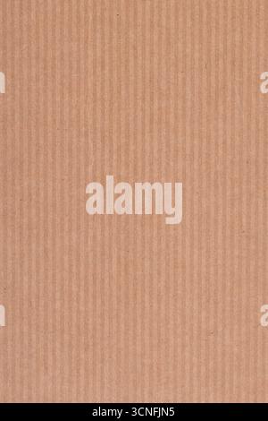 Macro shot of a plain brown cardboard surface showing vertical ridges and natural fiber texture. Ideal for packaging or material reference. Stock Photo