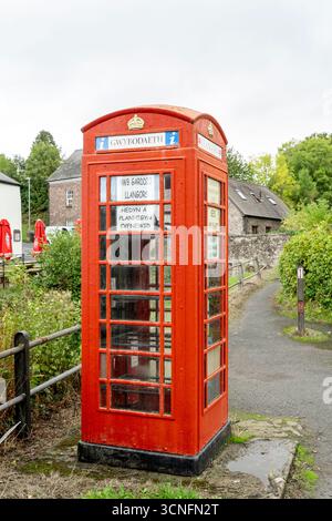 Old redundant public red telephone kiosk used as a community exchange point for seeds and plants with information in both English and Welsh language Stock Photo