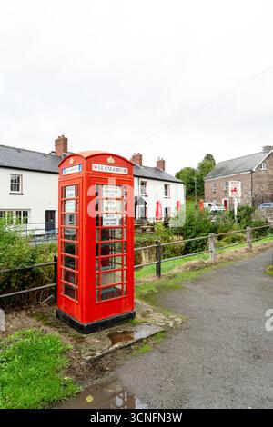 Old redundant public red telephone kiosk used as a community exchange point for seeds and plants with information in both English and Welsh language Stock Photo