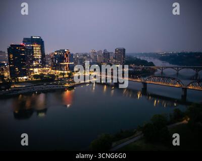 Aerial night view of downtown Saskatoon, Saskatchewan, featuring the city skyline, bridges, and illuminated streets. Stock Photo