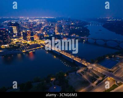 Aerial night view of downtown Saskatoon, Saskatchewan, featuring the city skyline, bridges, and illuminated streets. Stock Photo