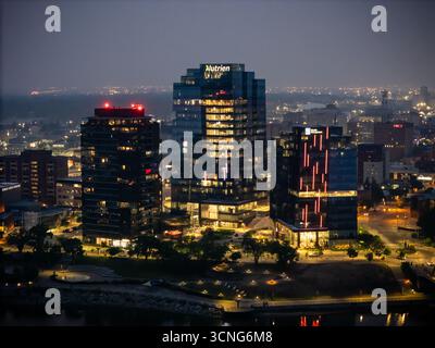 Aerial night view of downtown Saskatoon, Saskatchewan, featuring the city skyline, bridges, and illuminated streets. Stock Photo