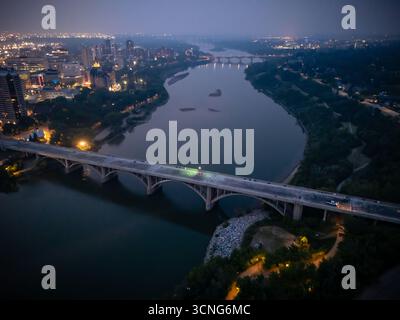 Aerial night view of downtown Saskatoon, Saskatchewan, featuring the city skyline, bridges, and illuminated streets. Stock Photo