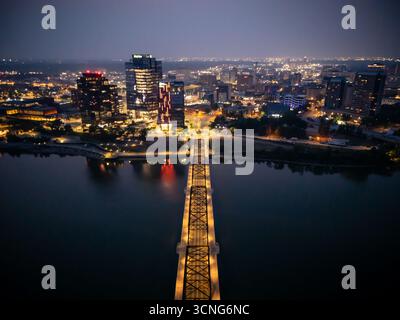 Aerial night view of downtown Saskatoon, Saskatchewan, featuring the city skyline, bridges, and illuminated streets. Stock Photo