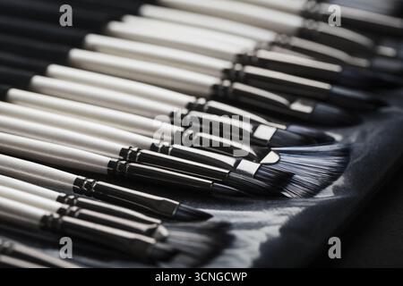 Paint tubes, brushes for painting and palette knifes on old wooden background Stock Photo
