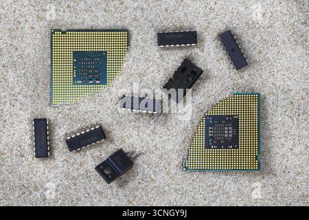 Radio-electronic components, microcircuits, transistors, central processors on pure quartz sand, from which semiconductors are made. Stock Photo