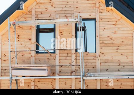 Residential building under construction, featuring a natural wood siding facade and scaffolding for ongoing work on the exterior Stock Photo