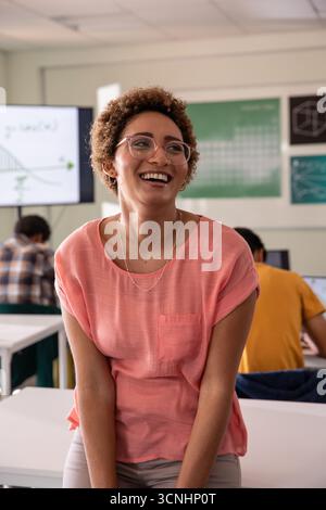 African american teacher guiding teenage students sitting in classroom Stock Photo