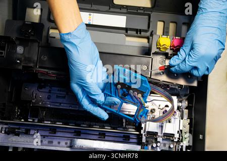 Top view of technician repairing and using printer repair tools. Stock Photo