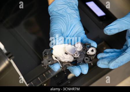 Top view of technician inspecting printer gear assembly. Stock Photo