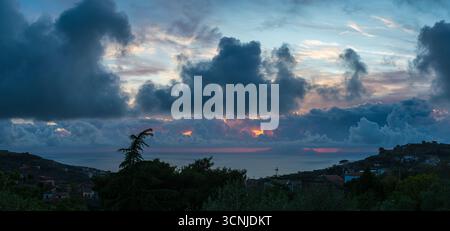 Panoramic and colorful view of a dramatic sunset over the Sorrento peninsula in Italy Stock Photo