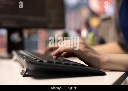 Software expert at workstation programming on pc and writing lines of code, using coding tools and a terminal window interface. Woman debugging software for web development. Close up. Stock Photo