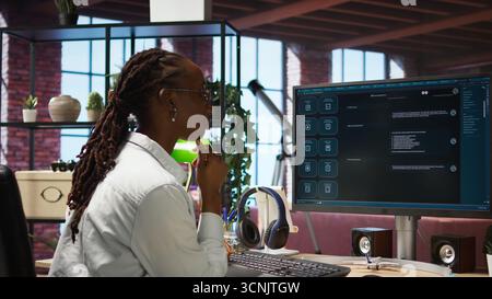 Woman at home asks questions to AI LLM chatbot virtual assistant answering user prompts. Person receiving helpful information from artificial intelligence large language model program on PC, camera A Stock Photo