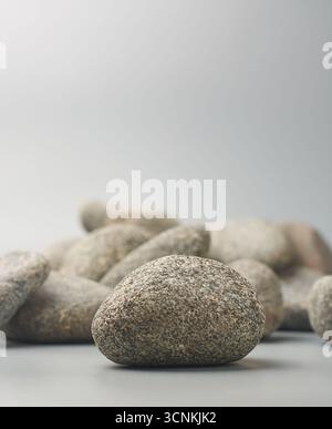 close-up of gray pebble or river stones with smooth surface and speckled texture isolated gray background, landscaping and aquarium decoration Stock Photo