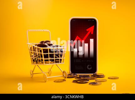Inflation concept with smartphone showing rising bar chart and red arrow next to shopping cart full of coins on yellow background, symbolizing price i Stock Photo