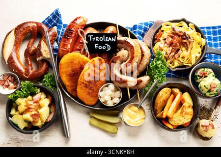 Various austrian dishes- schnitzel, sausages, potatoes, Knodel, salad and sauces on a light background. Top view. Stock Photo