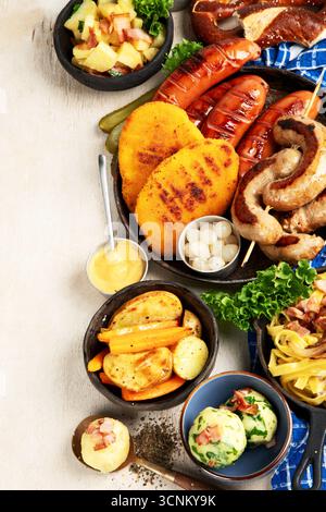 Various austrian dishes- schnitzel, sausages, potatoes, Knodel, salad and sauces on a light background. Top view. Copy space. Stock Photo