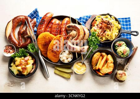 Various austrian dishes- schnitzel, sausages, potatoes, Knodel, salad and sauces on a light background. Top view. Stock Photo