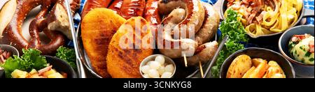 Various austrian dishes- schnitzel, sausages, potatoes, Knodel, salad and sauces on a light background. Top view. Panorama. Stock Photo
