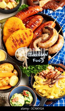 Various austrian dishes- schnitzel, sausages, potatoes, Knodel, salad and sauces on a light background. Top view. Stock Photo