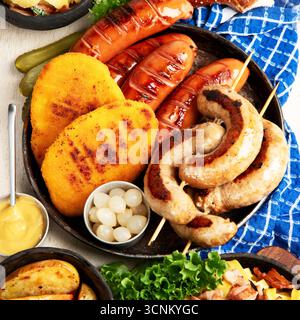 Various austrian dishes- schnitzel, sausages, potatoes, Knodel, salad and sauces on a light background. Top view. Stock Photo