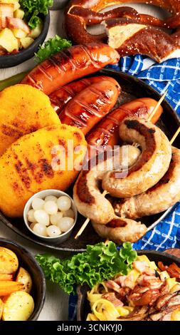 Various austrian dishes- schnitzel, sausages, potatoes, Knodel, salad and sauces on a light background. Top view. Stock Photo