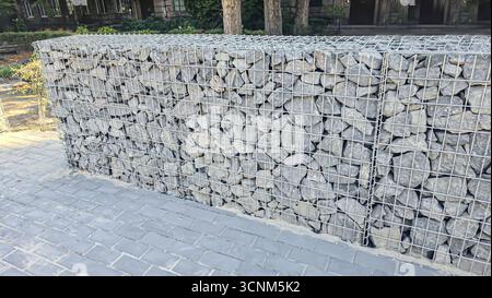 Stone fence construction. Mesh base with stones inside. Open space design. Territory fencing. Stock Photo