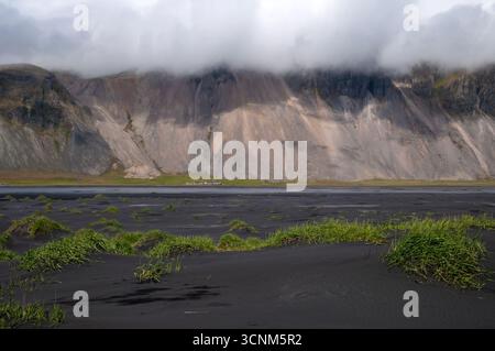 Stokksnes Iceland, view across black sand dunes to mountains shrouded in clouds Stock Photo