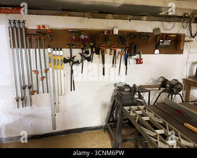 Jenkintown, Pennsylvania, USA - April 25, 2025: A well organized workshop with hand and power tools on a pegboard wall. Stock Photo