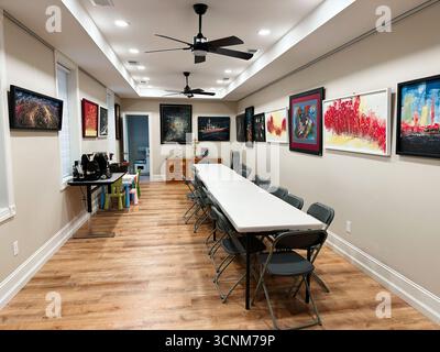 Philadelphia, Pennsylvania, USA - April 28, 2025: Bright meeting room in the USA with a long table, folding chairs, and colorful artwork along the wal Stock Photo