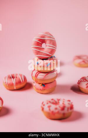 Stack of Pink Donuts on Pink Backdrop Stock Photo