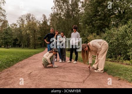 Children draw a big heart on a path in the park. Stock Photo