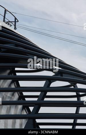 A close-up of a curved steel structure, creating a powerful pattern of parallel lines. The modern design is ideal for corporate or technology backgrou Stock Photo
