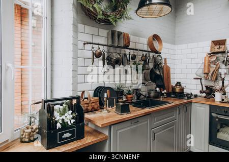 A bright kitchen features wooden countertops and vintage kitchenware hanging on the wall. Stock Photo