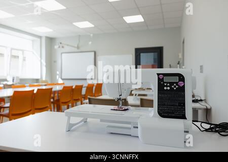 Modern sewing machine in a bright classroom ready for creative projects and learning Stock Photo