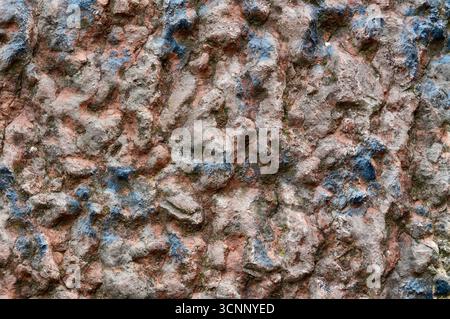 The texture of the stone is painted with blue and red paint. Stock Photo