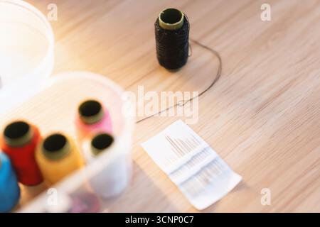 Sewing supplies on wooden table with thread spools and pattern - West Lake in Huizhou, Guangdong Province, China, is a tourist attraction featuring ancient architecture Stock Photo