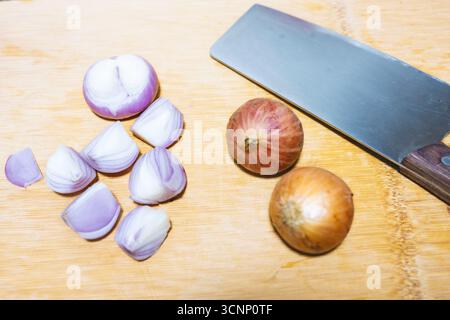 Chopped shallots and whole onions on wooden cutting board with chef's knife - West Lake in Huizhou, Guangdong Province, China, is a tourist attraction featuring ancient architecture Stock Photo
