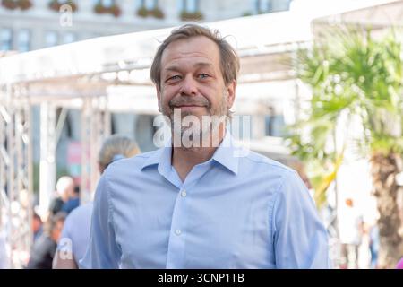 Emotional portrait of a 50-55-year-old man with a beard on a blurred urban background, close-up Stock Photo