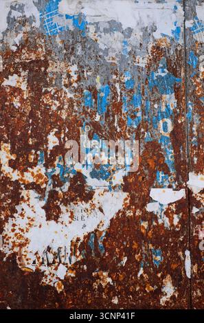 weathered rusty metal gate with old blue poster, puglia, italy Stock Photo
