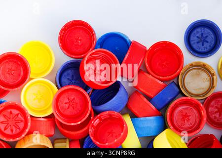 Colorful plastic bottle caps close-up on. Pile of multicolored plastic caps used for recycling with copy space. Stock Photo