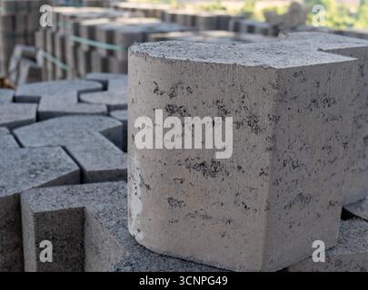 Concrete pavement blocks stacked on top of each other, interlocking pavers ready to be laid on the road. Stock Photo