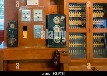 switchboard with indicator lights. on the left is an older electrical meter or control box. exhibition, Krung Thep Aphiwat exhibition, Bangkok Stock Photo